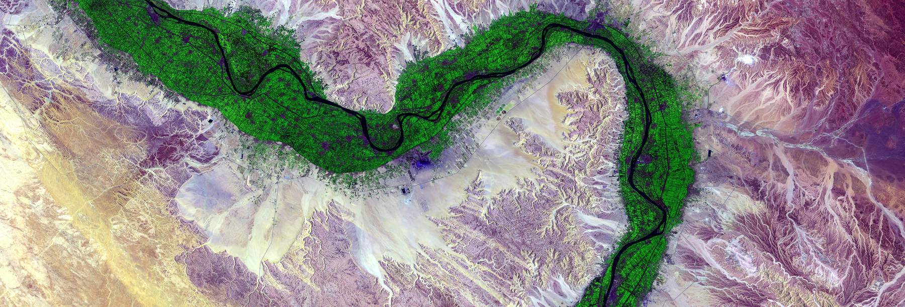False-color aerial image of a single river channel crossing open terrain.